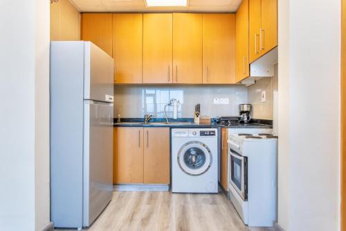 a kitchen with a washing machine and a washer at Live in the center of Mountains, Sea, Mangroves in Ras al Khaimah