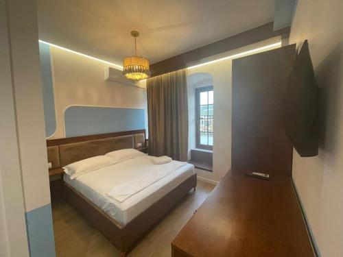 une chambre avec un lit et une grande fenêtre dans l'établissement Xha Llukani, à Berat