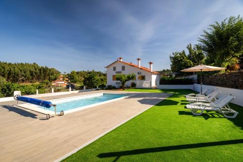 a swimming pool with a slide in a yard at Nature Tourism Quinta Nova in Castanheira de Pêra