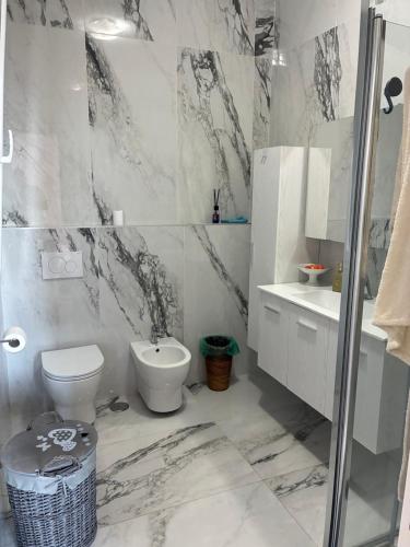 a marble bathroom with a toilet and a sink at Miramare in Crotone