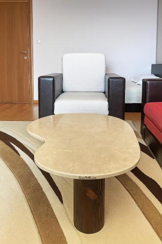a living room with a table and a chair at Hotel Avis in Sandanski