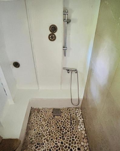 a bathroom with a shower with a pebble floor at Hebergement insolite Boat Near Paris in Thourotte