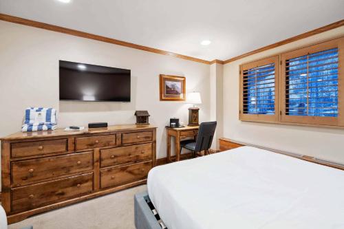 a bedroom with a bed and a desk and a television at Lodge Tower 281 in Vail