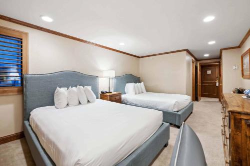 a hotel room with two beds and a desk at Lodge Tower 281 in Vail