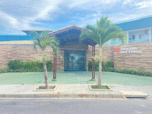 due palme di fronte a un edificio di Hotel Enseada dos Corais a Cabo de Santo Agostinho