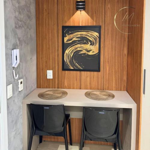 a table with two chairs and a painting on the wall at LM Setai Yacht Cabo Branco in Tambaú