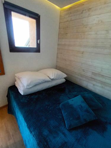 a small bedroom with a bed with a window at Apt coeur de station entièrement rénové in Valmeinier