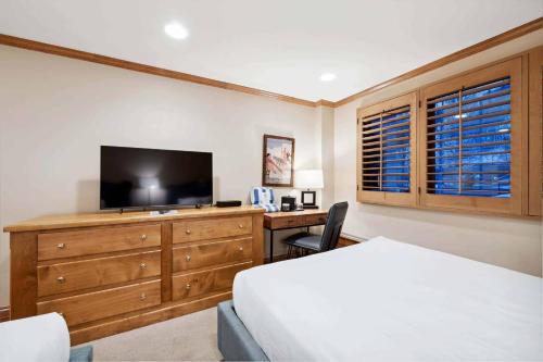 a bedroom with a bed and a dresser with a television at Lodge Tower 283 in Vail