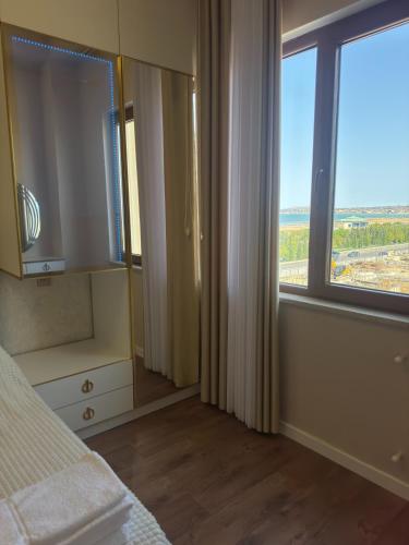 a bedroom with a bed and a large window at Boulevard Sumgait in Sumqayyt