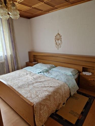 a bedroom with a bed with a wooden head board at Ferienwohnung im Dörfl in Mooslandl