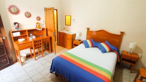 a bedroom with a bed and a desk and a desk at Casa de Alicia Habitación Mitla in Oaxaca City