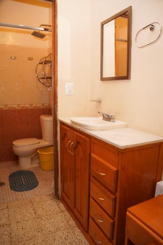 a bathroom with a sink and a toilet and a mirror at Casa de Alicia Habitación Mitla in Oaxaca City