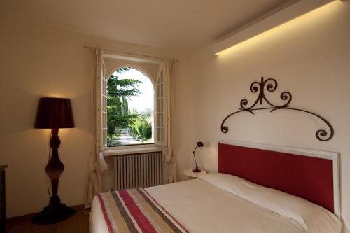 un dormitorio con una cama y una ventana en Villa Costasanti, en Lazise