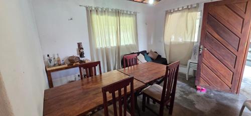 a dining room with a wooden table and chairs at Refúgio das Gameleiras in Monte das Gameleiras