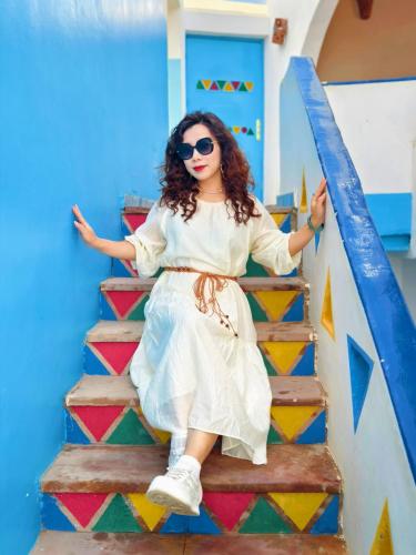 a woman sitting on the stairs of a house at DoroKa Nubian House in Aswan