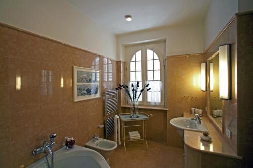 baño grande con 2 lavabos y 2 urinarios en Villa Costasanti, en Lazise