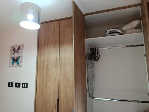 a kitchen with a wooden cabinet and a refrigerator at HOM I Con parking incluido Depto 1D1B in Puerto Varas