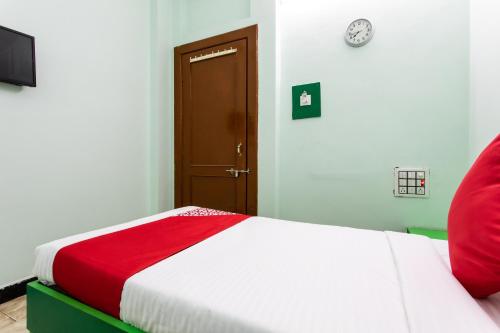 a bedroom with a bed with a red and white blanket at Super Hotel O Santushti in Dewās