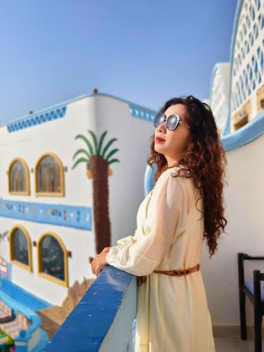 a young girl wearing sunglasses leaning on a railing at DoroKa Nubian House in Aswan