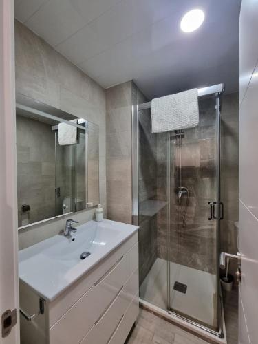 a bathroom with a white sink and a shower at Apartamento Puerto Blanes in Blanes