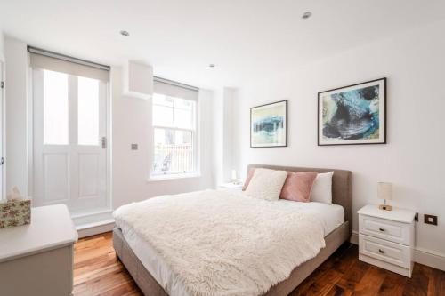 a white bedroom with a bed and a window at Central Stays at Liverpool Street in London