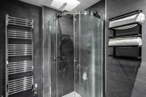 a bathroom with a shower with a glass door at Central Stays at Liverpool Street in London