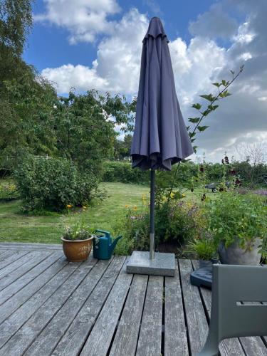 an umbrella sitting on top of a wooden deck at Velkommen til Søhøjlandet A! in Bryrup