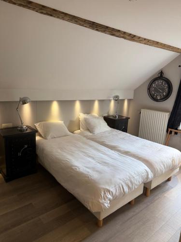a bedroom with a large white bed with two night stands at Hotel La Tonnellerie in Spa