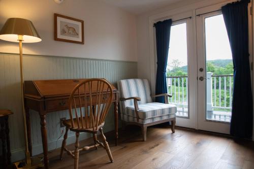 a room with a desk and a chair and a balcony at The Shire Woodstock in Woodstock