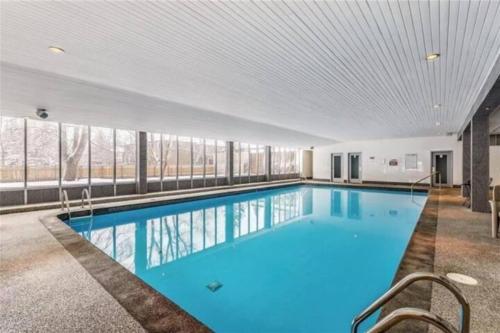 カルガリーにある2-Storey Condo in The Fortress with Pool, Gym, WiFi, Parkingの建物内の青い水の大きなプール