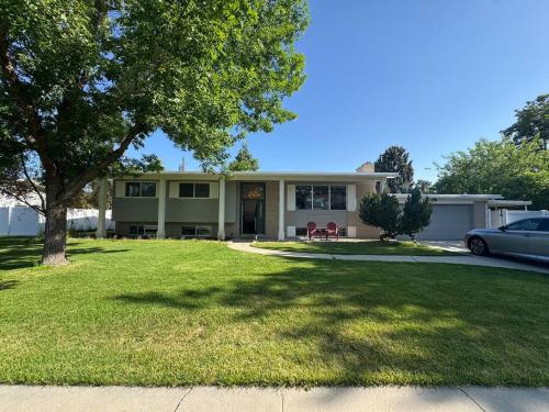 a house with a tree in front of a yard at Skiing, 2 Kitchens, 2 Units in 1, 80in TVs, WD, 2 Backyards in Salt Lake City