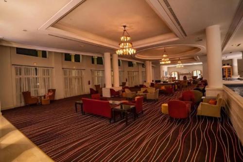 a hotel lobby with tables and chairs and a large at Vincci Saphir Palace & Spa in Hammamet