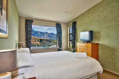a bedroom with a large bed and a window at Lakeview Lodge Two with Stunning Views in Queenstown