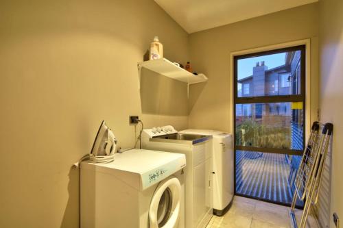 a laundry room with a washing machine and a window at Lakeview Lodge Two with Stunning Views in Queenstown