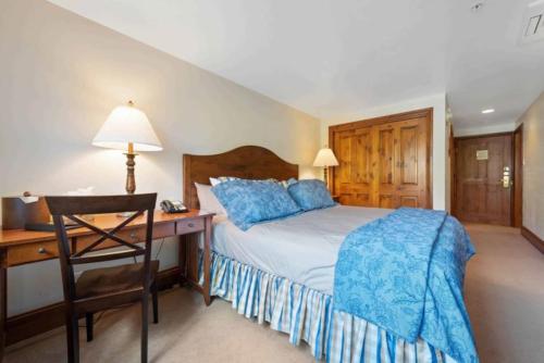 a bedroom with a bed and a desk with a bed sidx sidx sidx at Lodge Tower 290 in Vail
