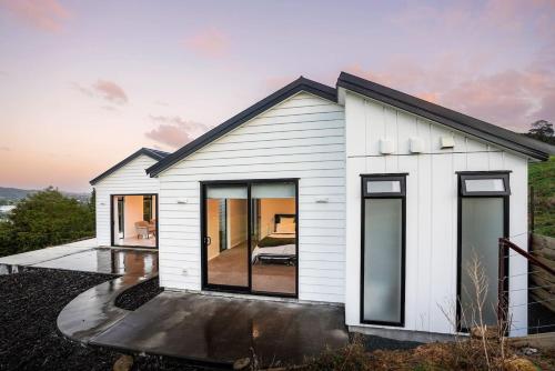a white house with large windows at Northland Nest By Aotearoa Escapes in Whangarei