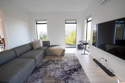 a living room with a couch and a rug at Northland Nest By Aotearoa Escapes in Whangarei