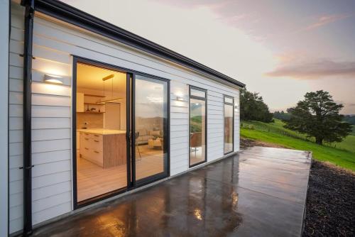 a house with large windows and a patio at Northland Nest By Aotearoa Escapes in Whangarei