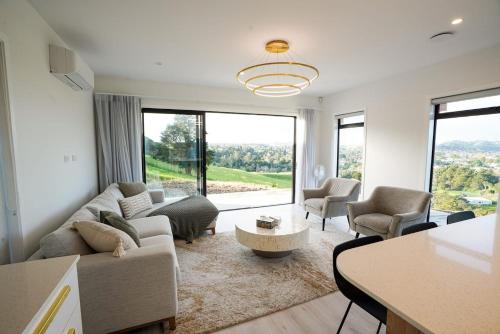 a living room with a couch and a table at Northland Nest By Aotearoa Escapes in Whangarei