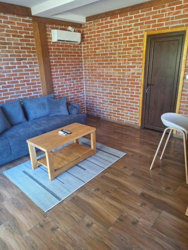 a living room with a blue couch and a coffee table at Banja na Drini - Lux vikendice, apartmani, na obali reke in Banja Koviljača
