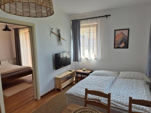 a bedroom with a bed and a flat screen tv at High Tatras Apartment J303 in Veľká Lomnica
