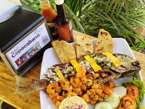 a plate of food with a fish on a table at Copacabana SV L in El Majahual