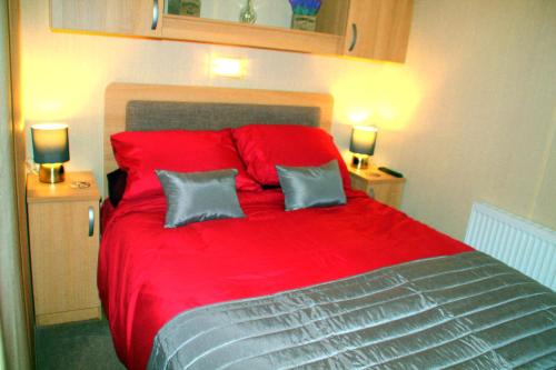 a bedroom with a red bed with two pillows at Island Bordeaux in Isle of Wight