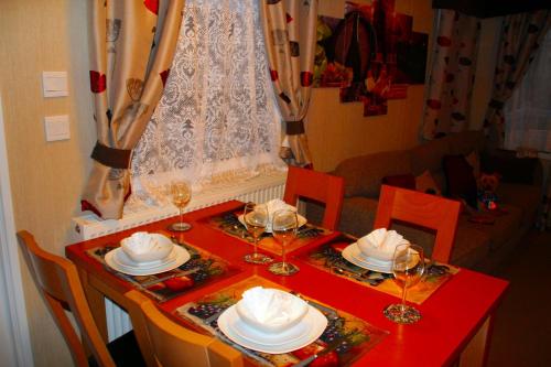 a red table with plates and wine glasses on it at Island Bordeaux in Isle of Wight