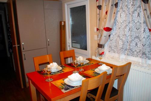 a dining room table with a red tablecloth and chairs at Island Bordeaux in Isle of Wight
