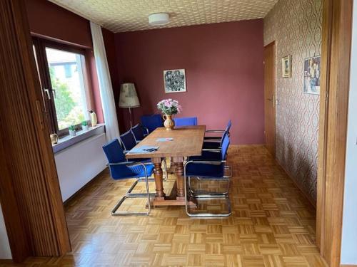 a dining room with a wooden table and blue chairs at Exclusives Ferienhaus in Frankenau im Sauerland in Frankenau