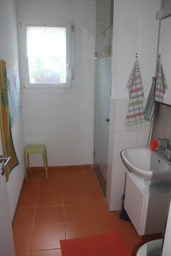 a bathroom with a sink and a toilet and a window at Beautiful 14 m2 room in Wünnewil