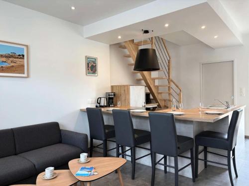 un salon avec une table et des chaises et une cuisine dans l'établissement Résidence L09-tregastel - Vacances à quelques pas de la mer et des commerces MAE-4871, à Trégastel