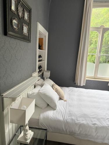 a bedroom with a white bed and a window at Hotel La Tonnellerie in Spa