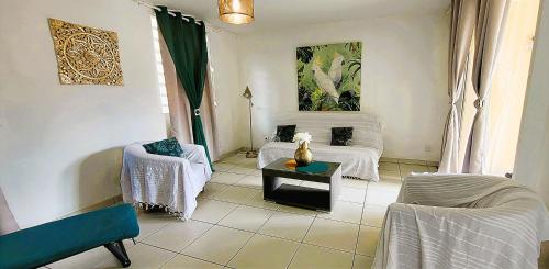 a living room with two chairs and a table at KANEL - Votre havre de paix à lAnse Mitan in Les Trois-Îlets